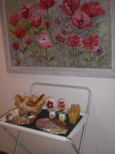 stół z chlebem i obraz czerwonych kwiatów w obiekcie B&B L'ourthe w mieście Houffalize