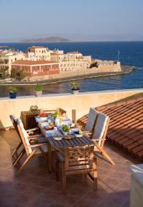 a wooden table and chairs on a patio with a view of the ocean at Dorothy's Dream in Chania