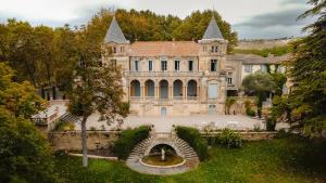 uma velha mansão com uma fonte em frente em Château Sainte cécile Chambres D'hôtes / Guest house in Castle Château sainte cécile em Nézignan-lʼÉvêque