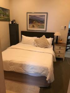 a bedroom with a large bed with white sheets and pillows at At 27 on Derby in Cape Town