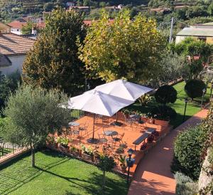 einen Sonnenschirm in einem Garten mit Tischen und Stühlen in der Unterkunft Farfalle E Gabbiani in Tramonti