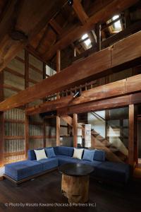 LOQUAT西伊豆 في إيزو: غرفة معيشة مع أريكة زرقاء وطاولة