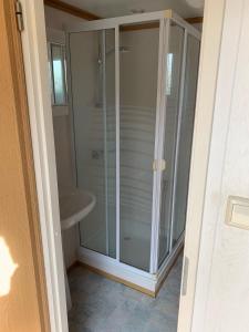 a glass shower in a bathroom with a sink at Camping Duin en Strand in Scharendijke