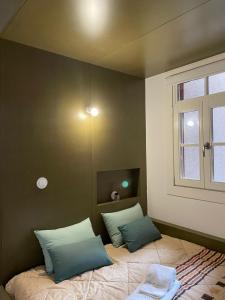 a bedroom with a bed with two pillows and a window at Sweet Love Family II in Coimbra