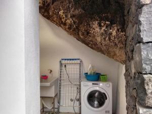 a room with a washing machine and a stone wall at Casita Tio Manuel in Valle Gran Rey