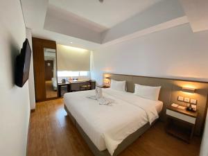Una cama o camas en una habitación de Grand Zuri Ketapang