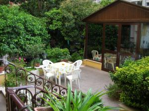patio ze stołem, krzesłami i altaną w obiekcie Gioia Guest House w Rzymie