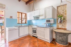una cucina con mobili bianchi e un lavandino di Ca Sa Cristeta de Sescola a Sa Pobla