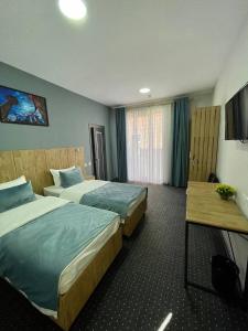 a hotel room with two beds and a television at BOBUR Hotel in Tashkent