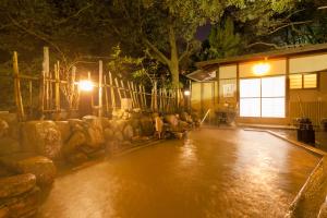 eine regengetränkte Straße in der Nacht mit einem Gebäude in der Unterkunft Arima Onsen Gekkoen Korokan in Kōbe