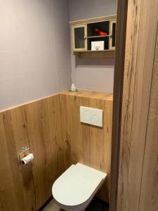 uma casa de banho com um WC branco num quarto de madeira em B&B De Rentmeesterhoeve em Reningelst