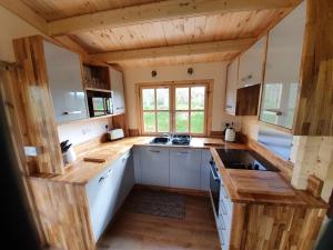 a kitchen with white cabinets and wooden counter tops at West Pool Cabin in Lincoln