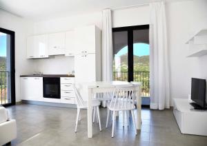 a white kitchen with a table and chairs in a room at Green Residence Olbia in Olbia