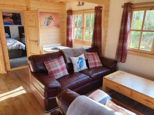 a living room with a leather couch and a table at East Pool Cabin in Lincoln