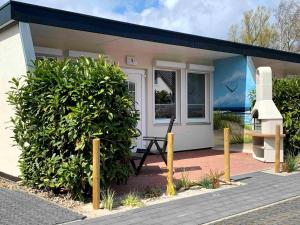 a small house with a bench in front of it at Bungalow-Park Ostseenordstern in Wustrow