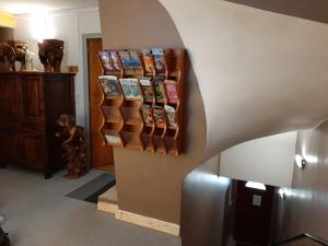 a room with a bunch of books on a wall at Hôtel Le Passage de Vallon in Vallon-Pont-dʼArc