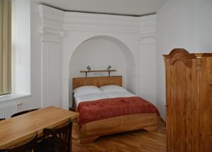 um quarto com uma cama e uma mesa de madeira em KostelApartmány em Liberec