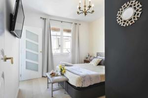 1 dormitorio con cama, espejo y lámpara de araña en Apartment Leonor en Barcelona