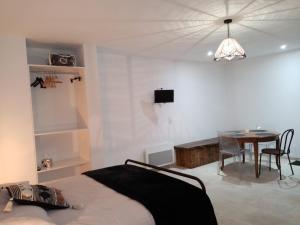 1 dormitorio con cama, mesa y comedor en La Gurlanne en Lasséran