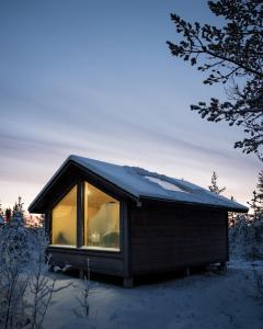 uma pequena cabana com uma janela na neve em Polar Lights Lodge em Sirkka