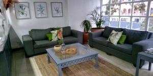 a living room with two couches and a coffee table at The Jack Rose Hotel, Rosebank, Gautrain in Johannesburg