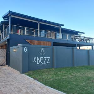 ein blaues Gebäude mit einem Schild an der Seite in der Unterkunft Le Bezz Guesthouse in Ballito