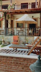 a patio with a table and an umbrella and chairs at Akropolis Guest House in Bergama