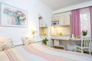 a small bedroom with a bed and a kitchen at F&aacute;bi&aacute;n Panzi&oacute; in Kecskem&eacute;t