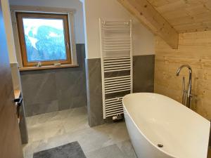 un bagno con vasca e finestra di Almchalet Hüttenzauber a Klippitztorl