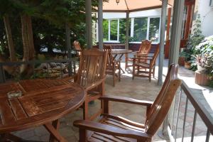 a patio with wooden chairs and tables and an umbrella at Private Residence Osobnyak in Odesa