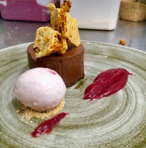 un dessert au chocolat sur une assiette avec une substance rose dans l'établissement The White Lion, à Ventnor