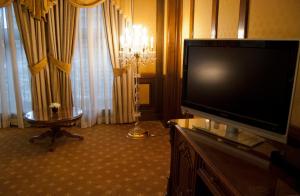 uma sala de estar com uma grande televisão de ecrã plano em Hotel Casa Capsa em Bucareste