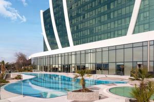 a large building with a swimming pool in front of it at Elite World Grand Istanbul Küçükyalı in Istanbul