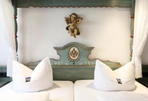 a bed with a teddy bear on the wall at Arthotel ANA Goggl in Landsberg am Lech