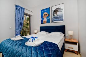 ユラタにあるWilla Tamara BlueApart Jurataのベッドルーム1室(ブルーベッド1台、タオル付)