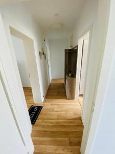 un couloir d'un appartement vide avec du parquet dans l'établissement Near Tram l 3 Beds l 2 Sleeping Room l Own Parking Space, à Bielefeld
