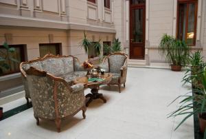 - 2 chaises et une table basse dans une cour dans l'établissement Hotel Casa Capsa, à Bucarest