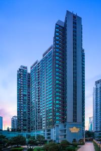 un edificio alto con muchas ventanas en una ciudad en Springdale Serviced Residence Guangzhou, en Guangzhou