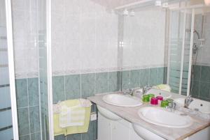 Baño con 2 lavabos y espejo en Chambres d'Hôtes Le Clos Ambels, en Ambialet