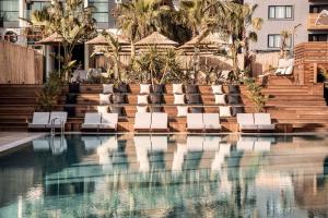 a swimming pool with lounge chairs in front of a building at Cook's Club Alanya - Adult Only 12 in Alanya