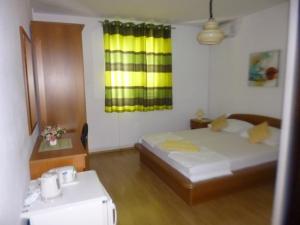 - une chambre avec un lit et une fenêtre jaune dans l'établissement Haus Pehar, à Baška Voda