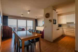 a kitchen and living room with a table and chairs at Royal C1 in Koksijde