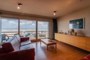 a living room with a couch and a view of the ocean at Royal C1 in Koksijde