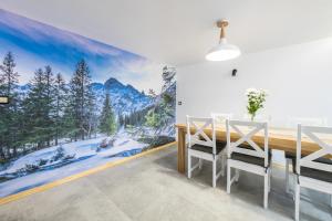 a dining room with a mountain mural on the wall at Osada Zagrody Dzianisz in Dzianisz