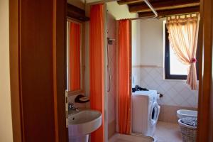 a bathroom with orange curtains and a sink and a toilet at Villa dei Vasari in Casoli