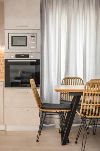 uma cozinha com uma mesa, 2 cadeiras e um micro-ondas em Serenity Home em Argostólion