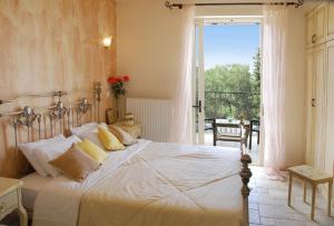 卡西奧皮的住宿－Villa Faidra，一间带一张白色大床的卧室和一个阳台