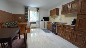 a large kitchen with wooden cabinets and a table at Panoráma Üdülő in Aggtelek