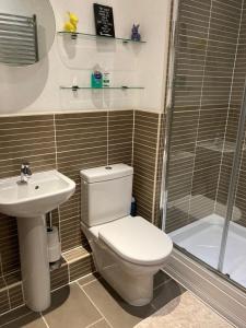 a bathroom with a toilet and a sink and a shower at Shorthorn Apartment, 53a Sea Road in Carlyon Bay