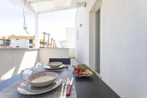 a table with plates of food on a balcony at Viva Vacanze in Porto Cesareo